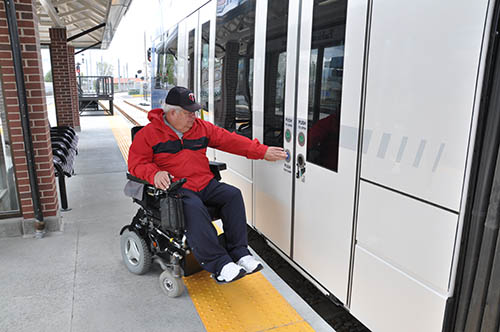 Man in wheelchair boarding train